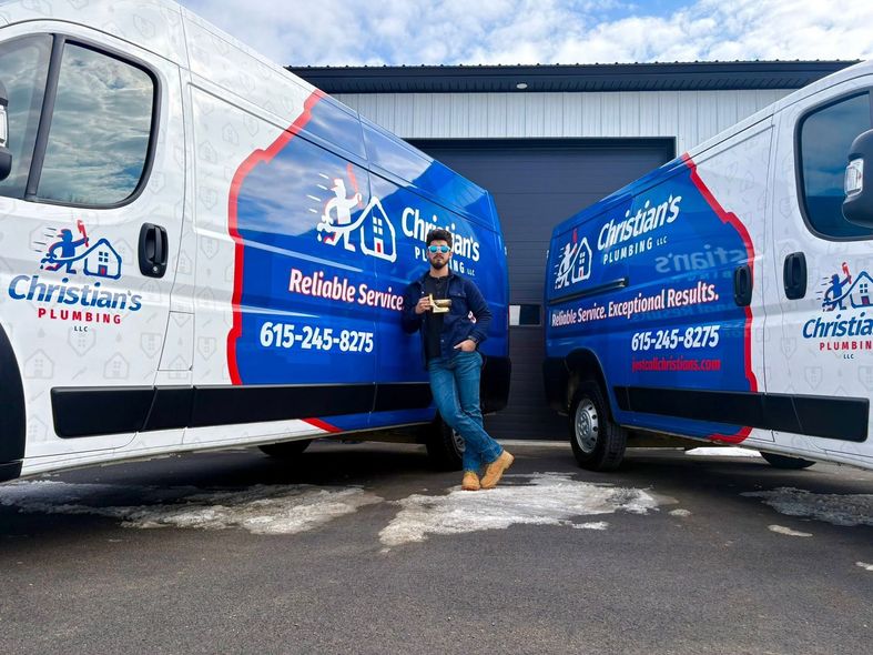 Man standing between two white-and-blue Christian’s Roofing vans in a parking lot