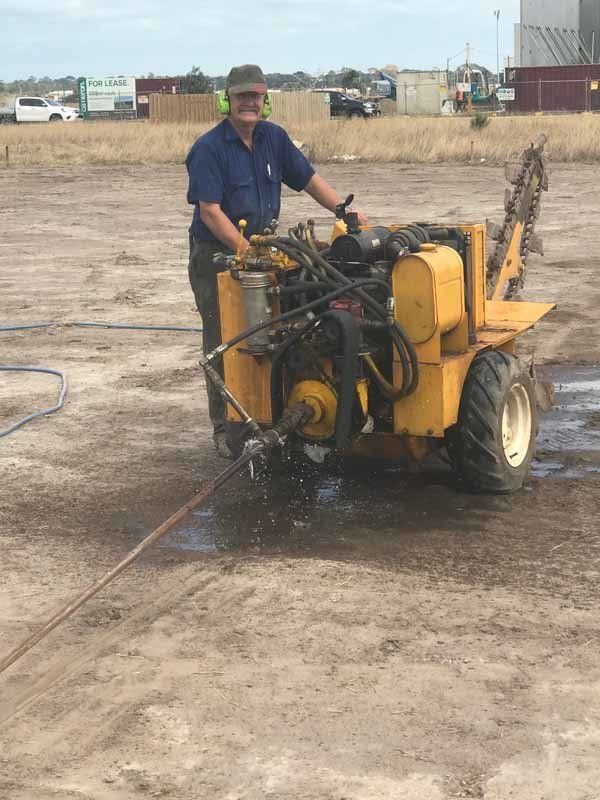 man standing next to drilling machine