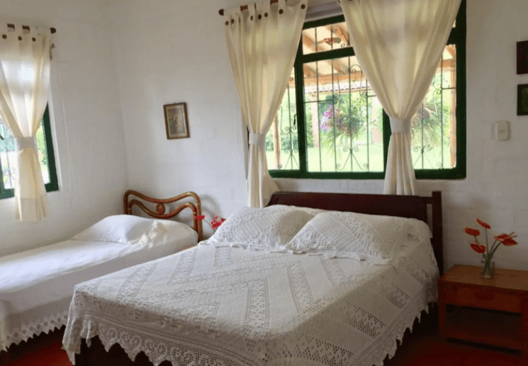 Un dormitorio con dos camas y una ventana con cortinas
