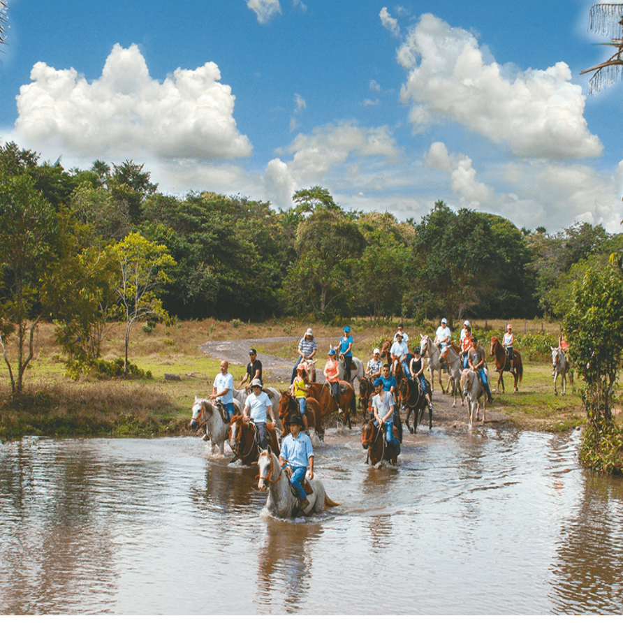 Un grupo de personas montando a caballo a través de un río