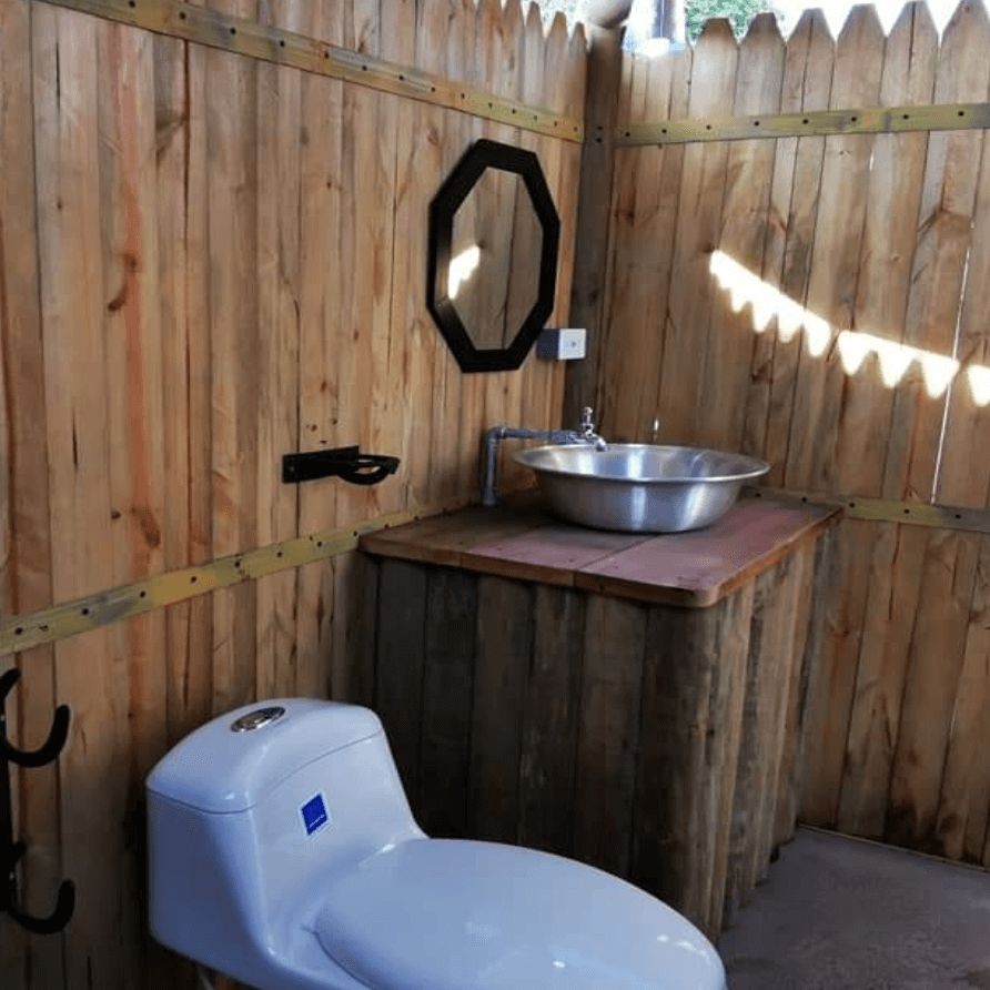 Un baño con inodoro, lavabo y espejo