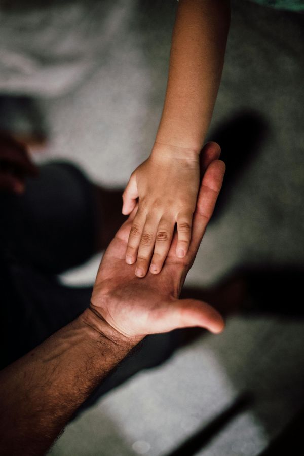A man in a suit and tie is sitting at a table talking to another man.