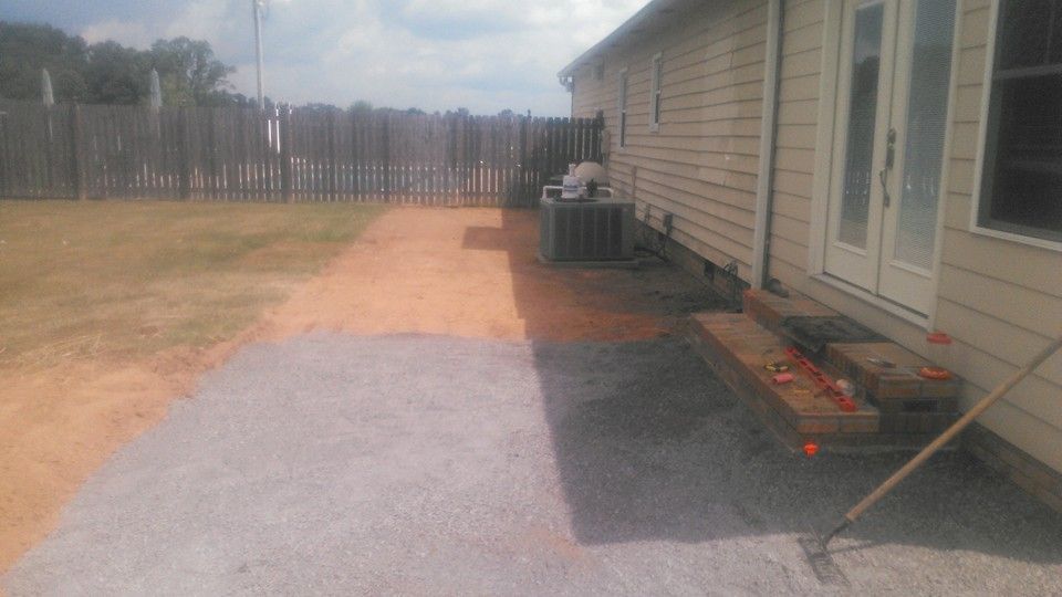 A house with a patio and a rake in front of it.