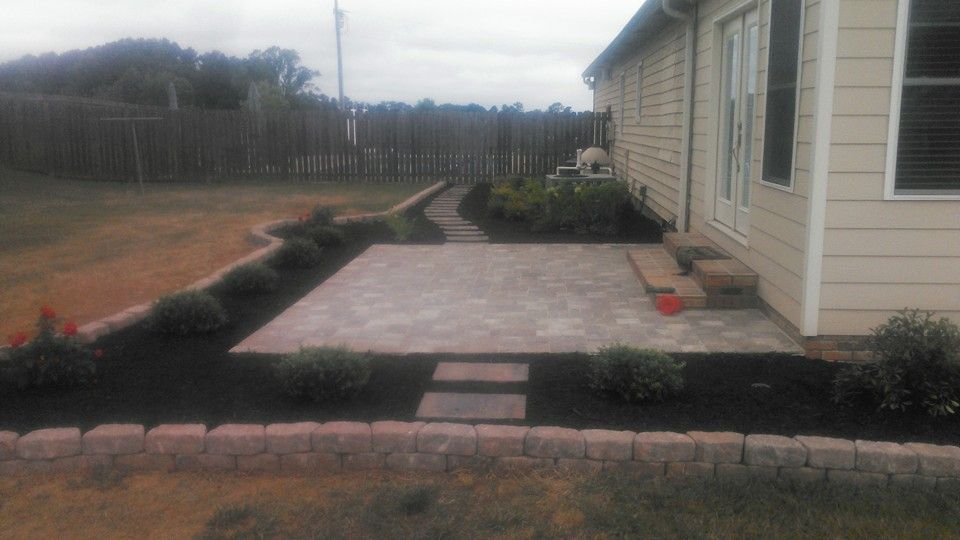 A house with a patio and a walkway in front of it.