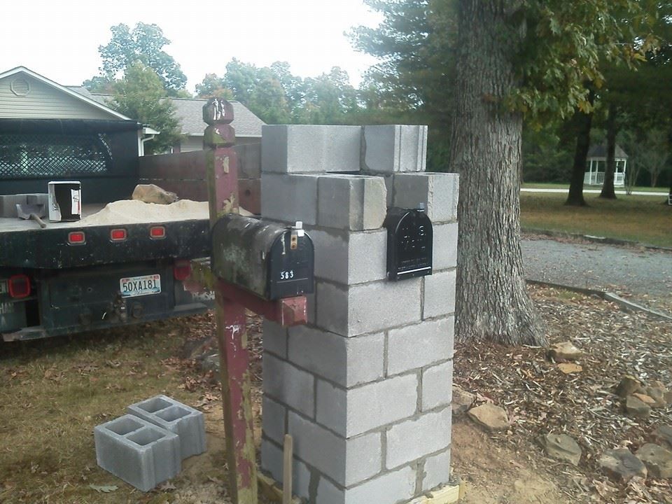 A brick post with a mailbox attached to it