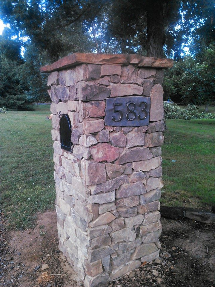 A stone post with a mailbox and a sign that says 583 on it.