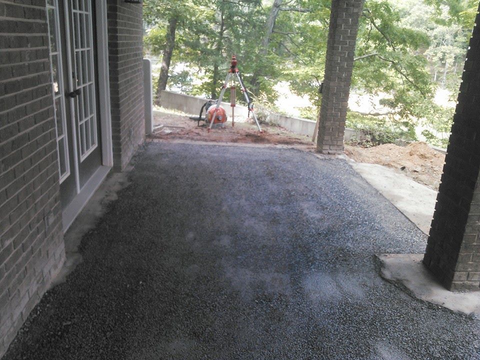 A brick building with a gravel driveway in front of it