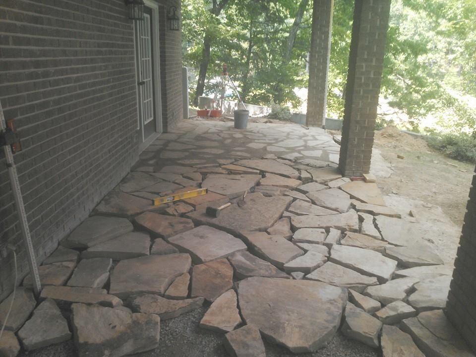 A stone walkway is being built in front of a brick building