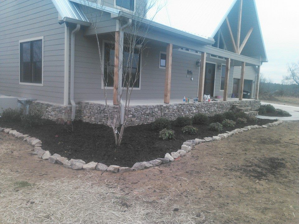 A house with a porch and a stone wall