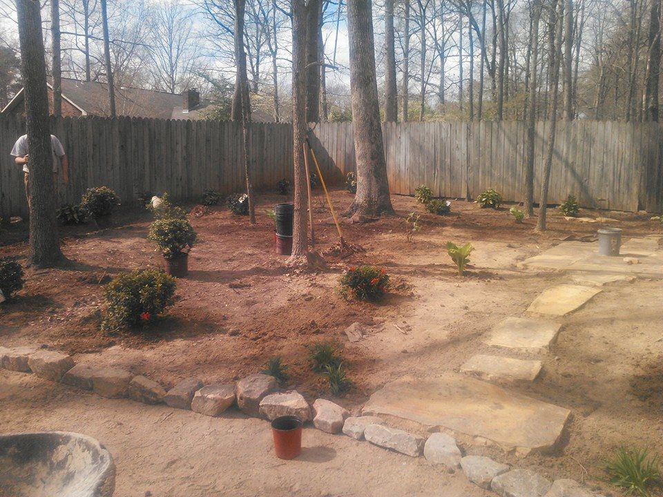 A backyard with a fence and a few potted plants