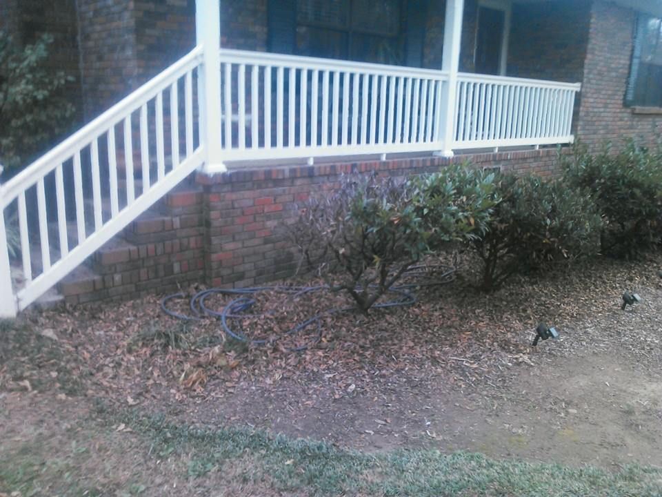 A porch with a white railing and stairs leading up to it.
