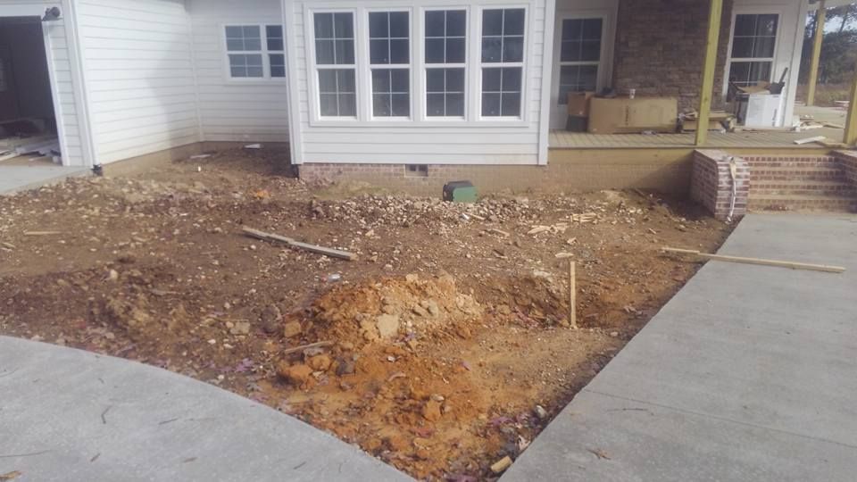 A white house with a lot of dirt in front of it