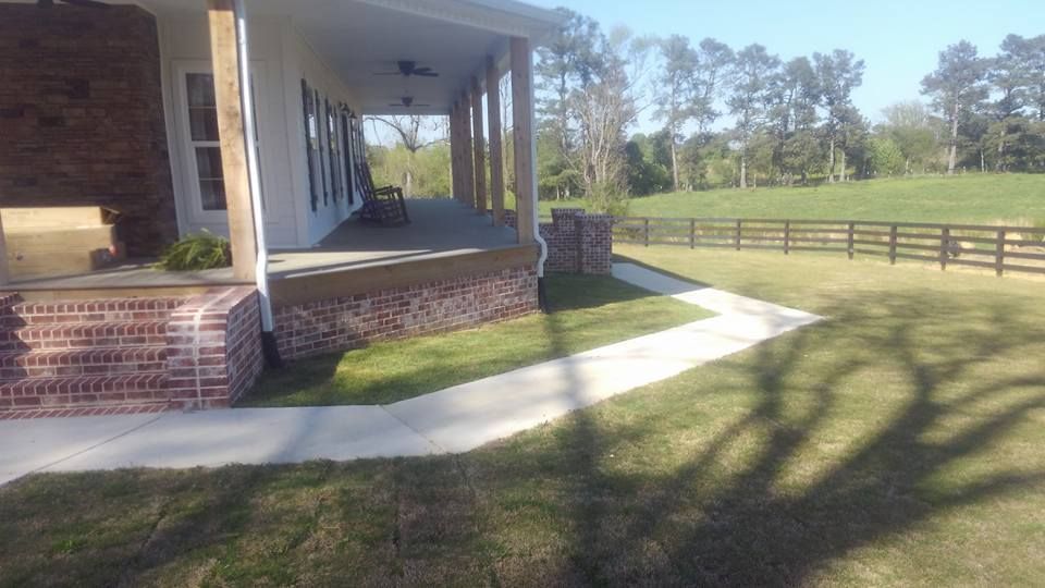 A house with a porch and a walkway leading to it.