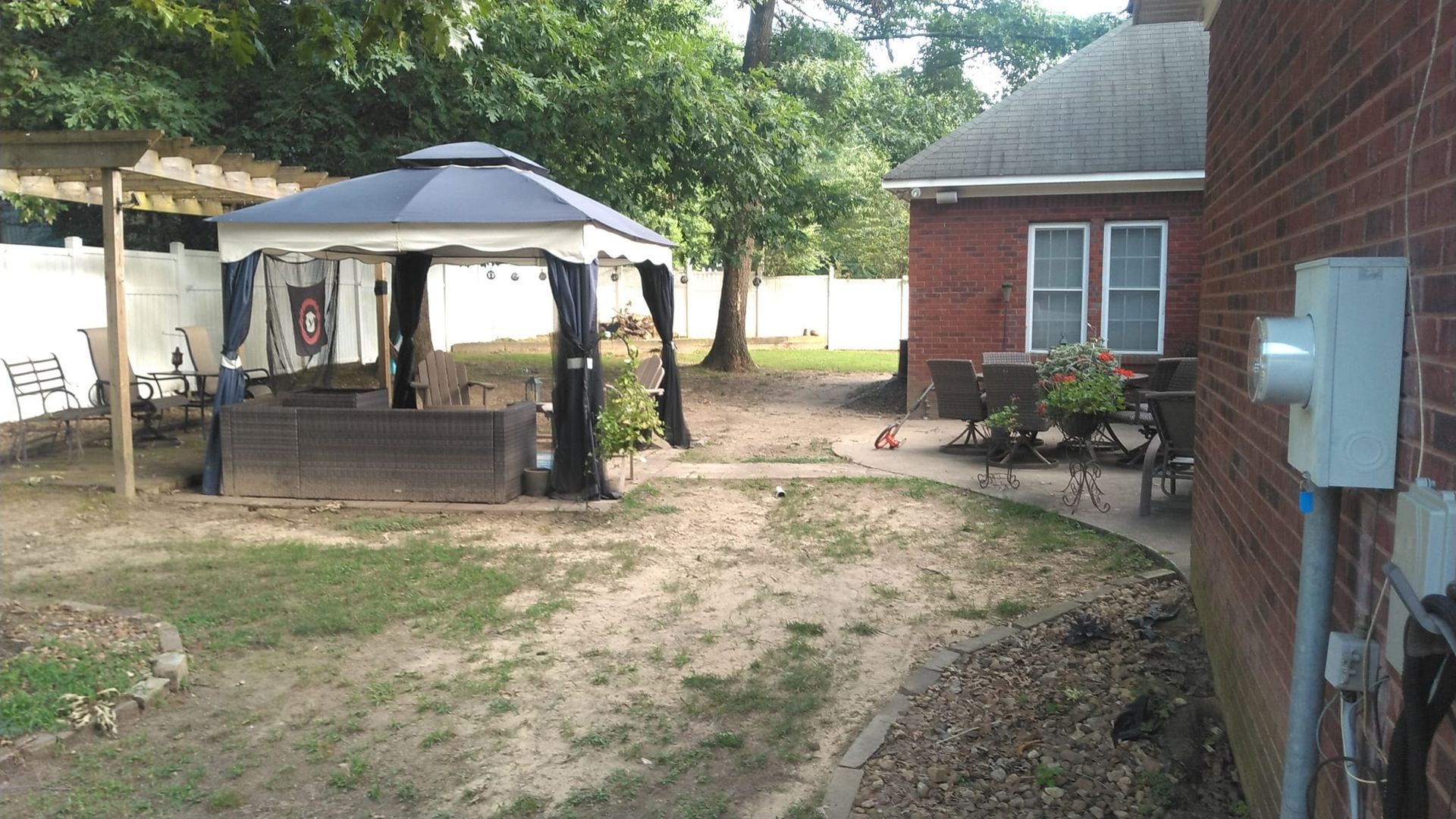 A brick house with a gazebo in the backyard