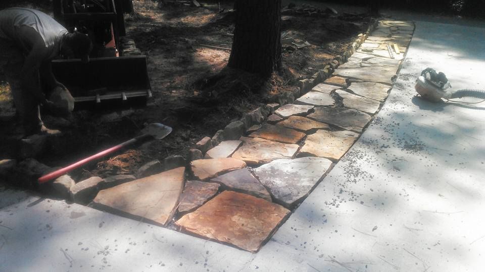 A man is working on a stone walkway.