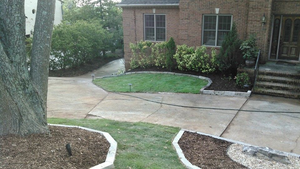 A brick house with a circular lawn in front of it