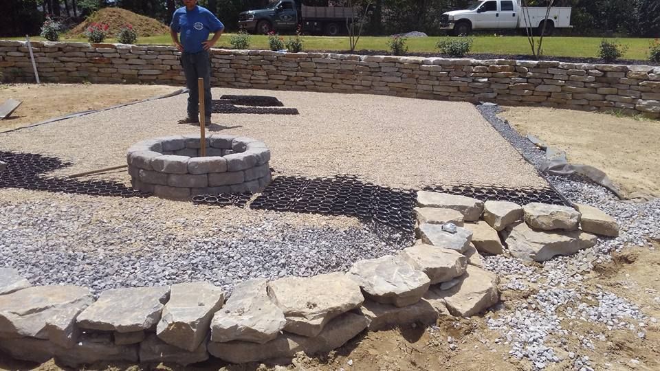 A man is standing in front of a fire pit