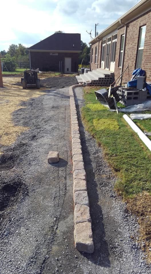 A brick wall is being built in front of a brick building.