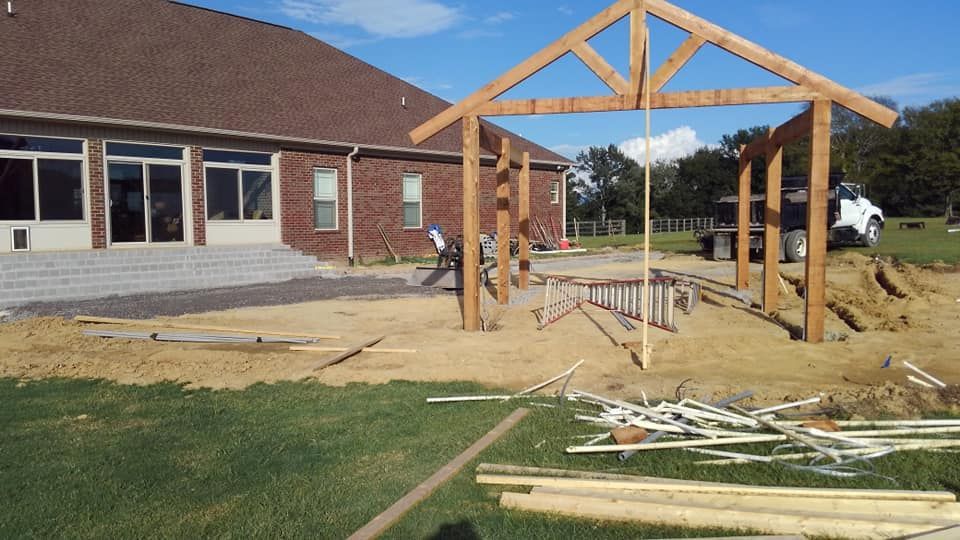 A wooden structure is being built in front of a brick house