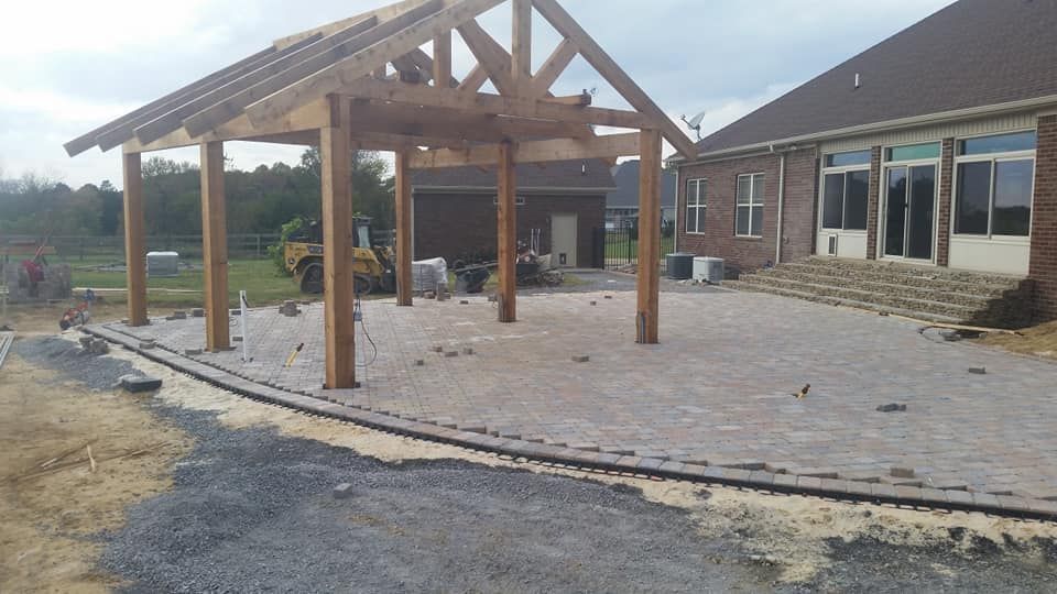 A large wooden structure is being built in the backyard of a house.