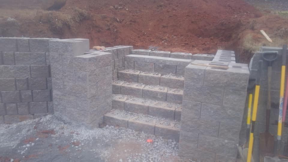 A brick wall with stairs being built on top of it.