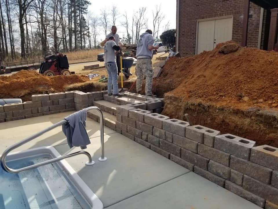 A brick wall is being built around a hot tub