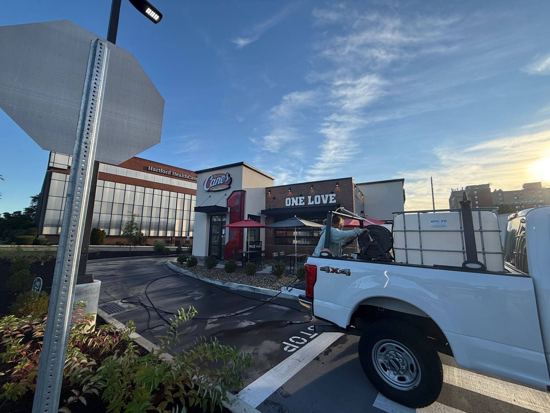 A white truck with water tanks parked outside a fast-food restaurant 