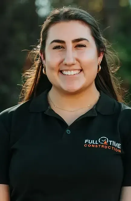 Woman wearing a black polo shirt, smiling. The shirt has 