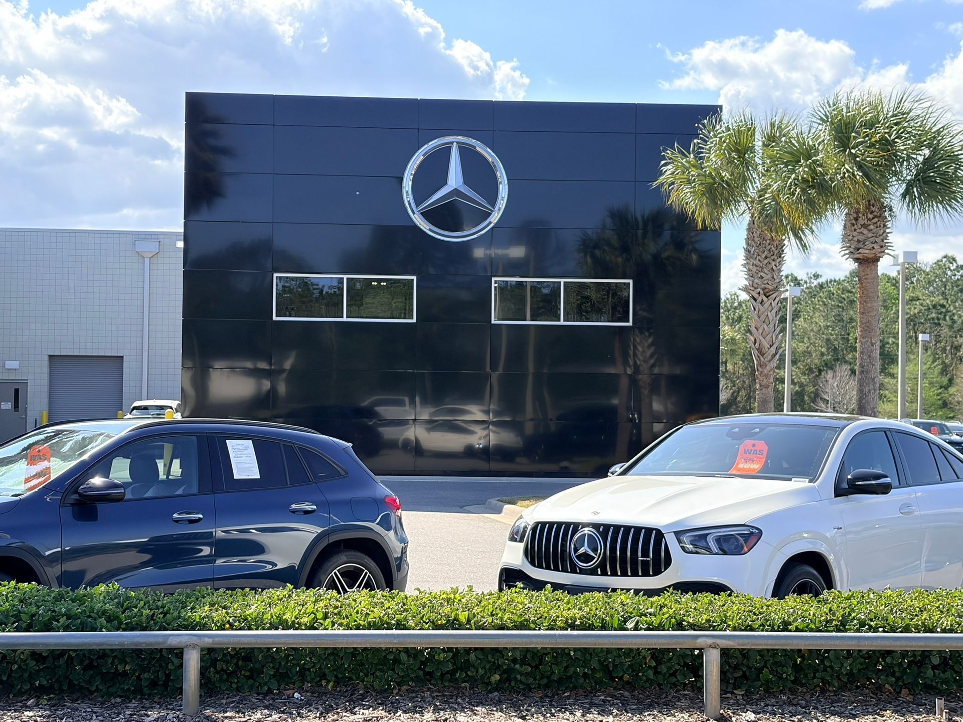 Night view of a Honda car dealership with illuminated buildings, vehicles, and a service center.