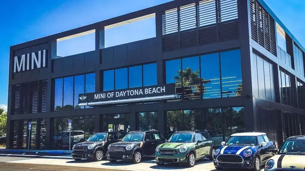 MINI of Daytona Beach dealership with a row of parked MINI Coopers in front.