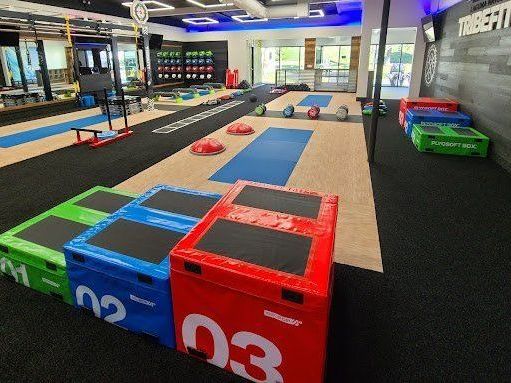 A gym with a lot of colorful boxes on the floor.