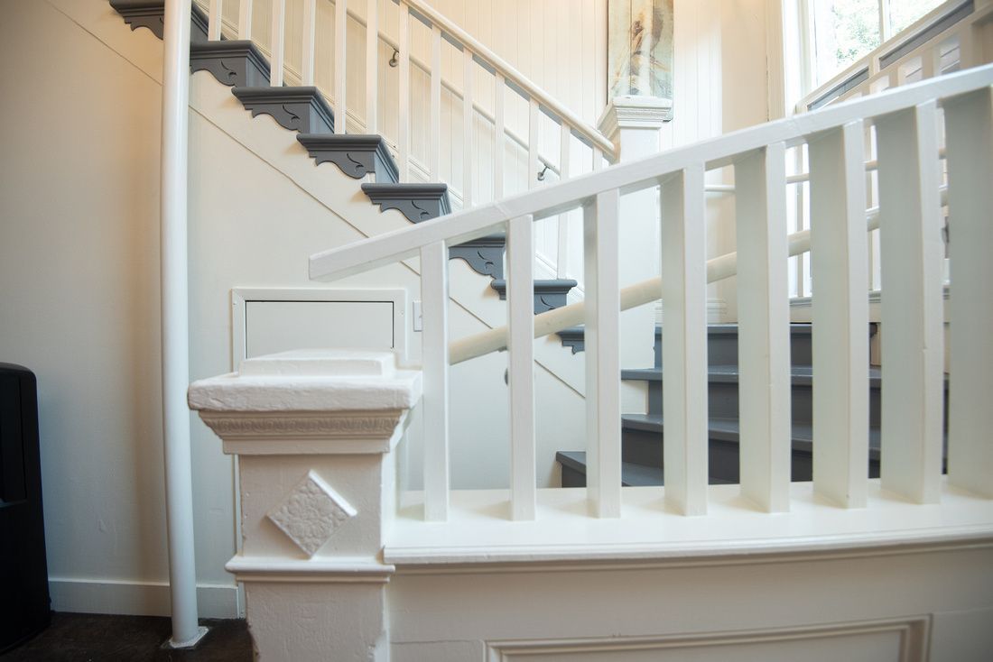 A white staircase with black steps and a white railing in a house.