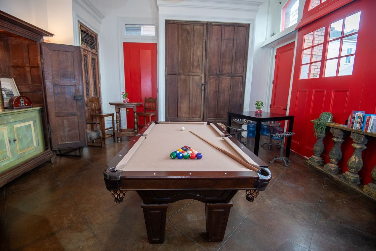 A living room with a pool table and a piano.