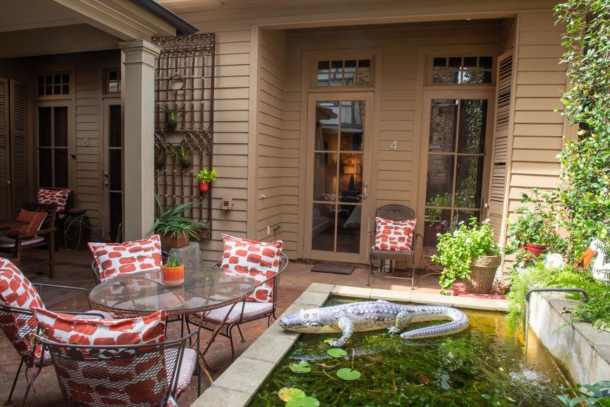 A patio with a pond and a table and chairs