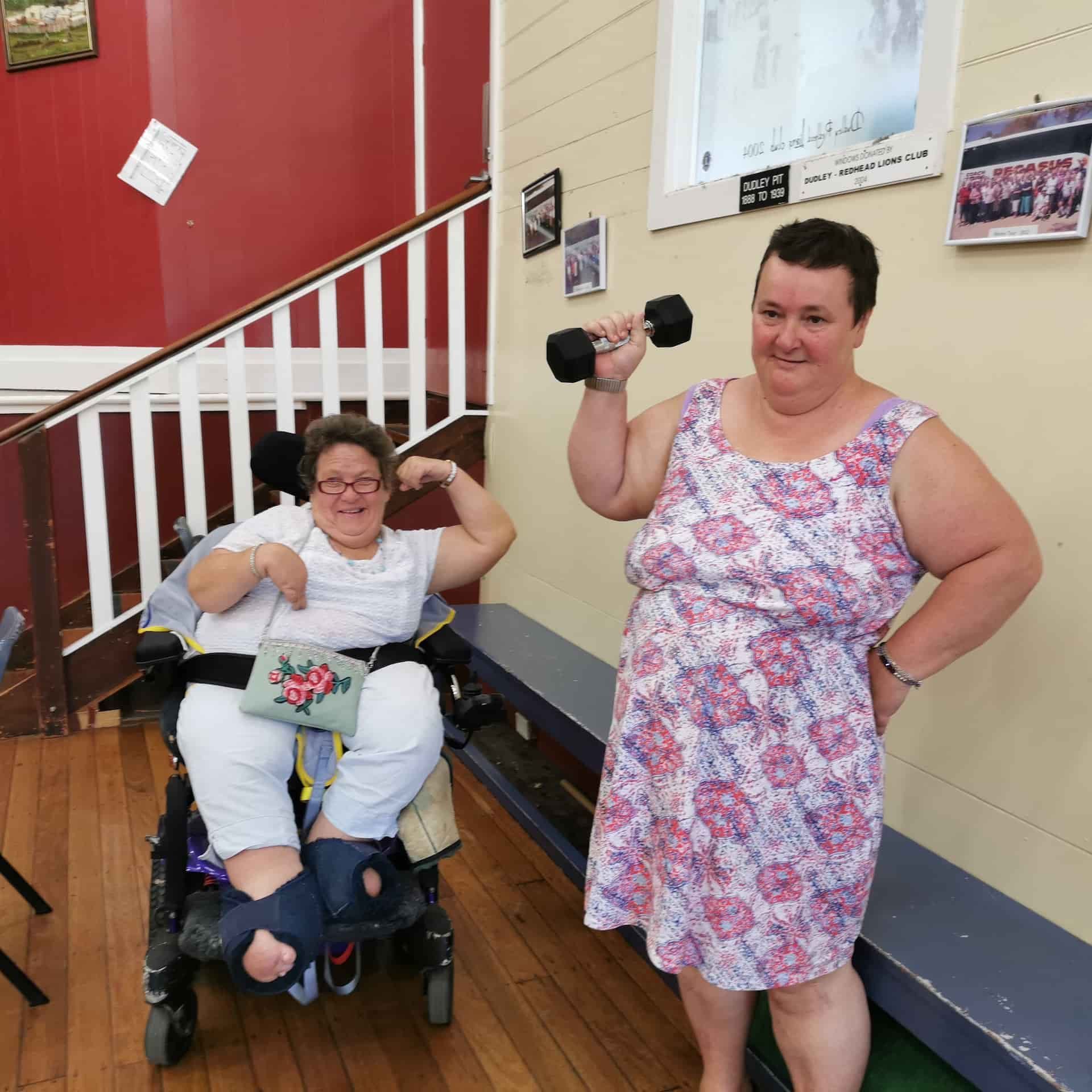 A Woman Lifting a Dumbbell Next to a Woman in a Wheelchair —True Form Fitness In Gwandalan, NSW