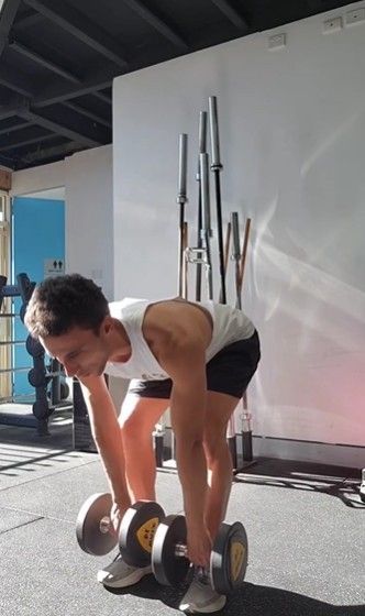 A Man is Lifting Dumbbells in a Gym —True Form Fitness In Gwandalan, NSW