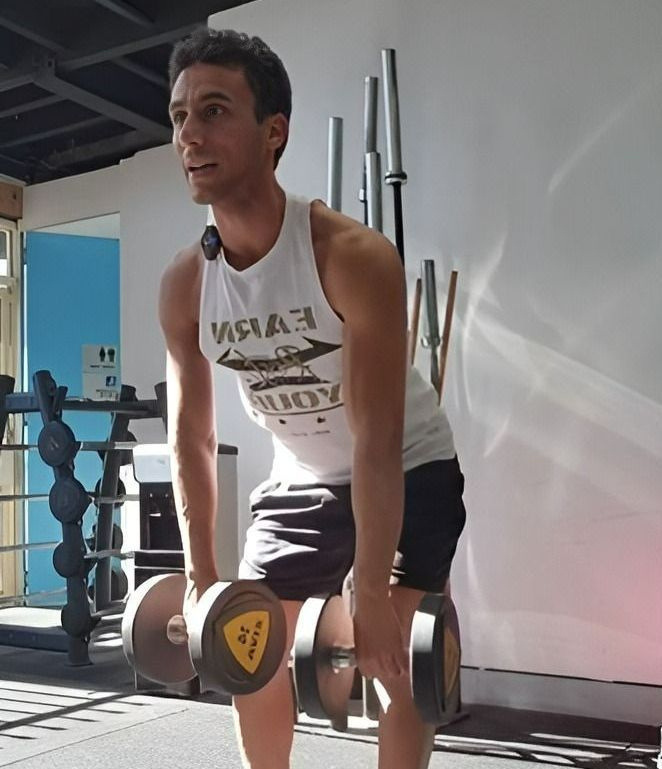 A Man in a White Tank Top working out in a gym —True Form Fitness In Gwandalan, NSW