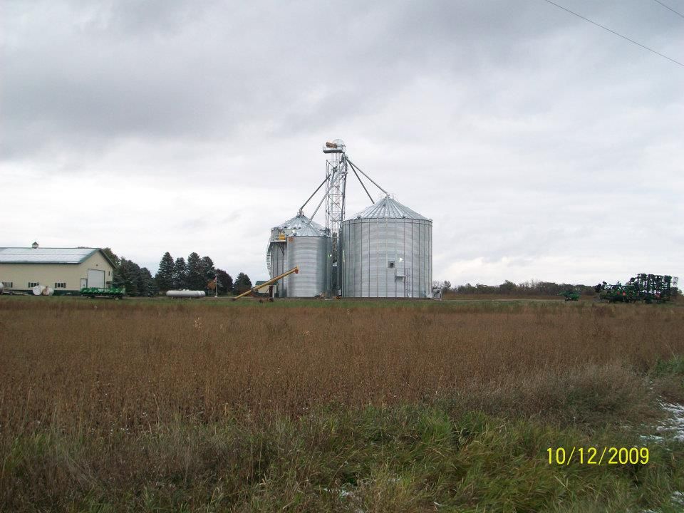 Two silos are sitting in the middle of a field.