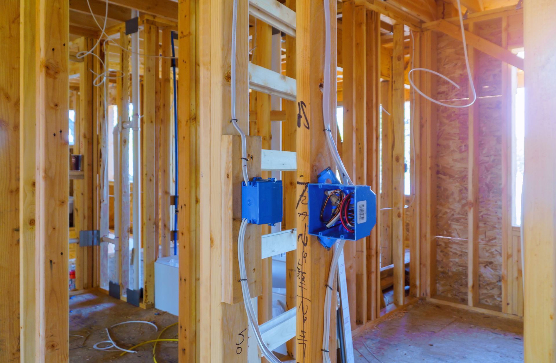 A house is being built with wooden beams and electrical wires.