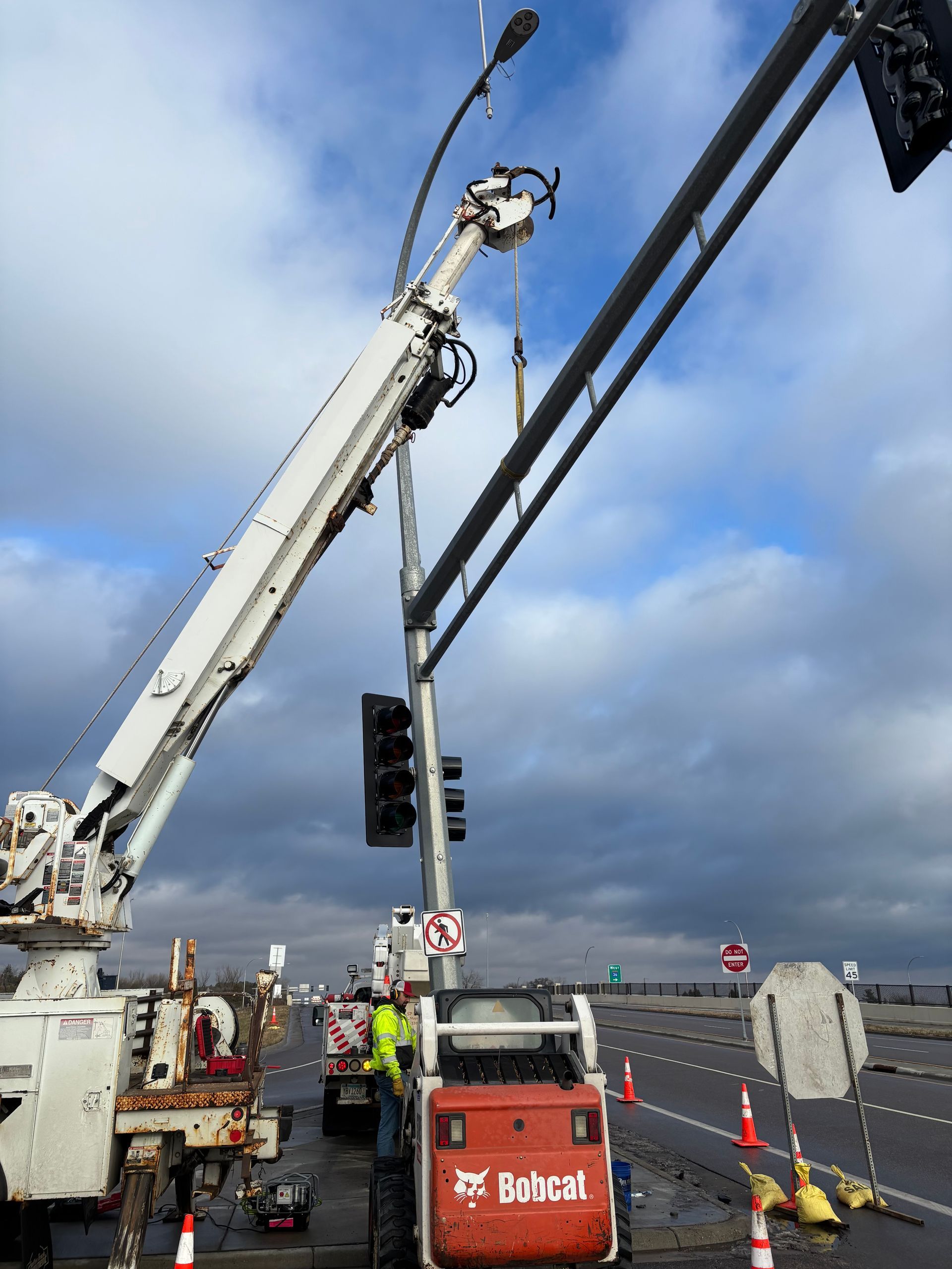 A bobcat is being used to install a traffic light