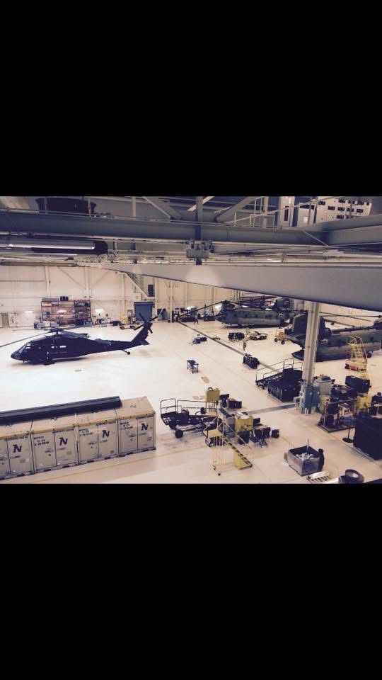 A helicopter is sitting on the ground in a hangar