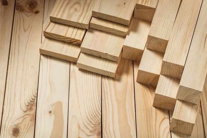 Un montón de tablas de madera están apiladas una encima de otra sobre una mesa de madera.