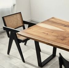 Una mesa de comedor de madera con dos sillas en una habitación.