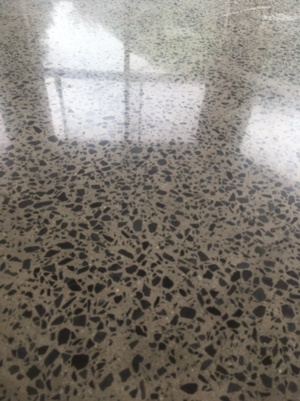 A Man Is Painting A Yellow Floor With A Roller — Fantastic Frank's Concrete Resurfacing In Byron Bay, NSW