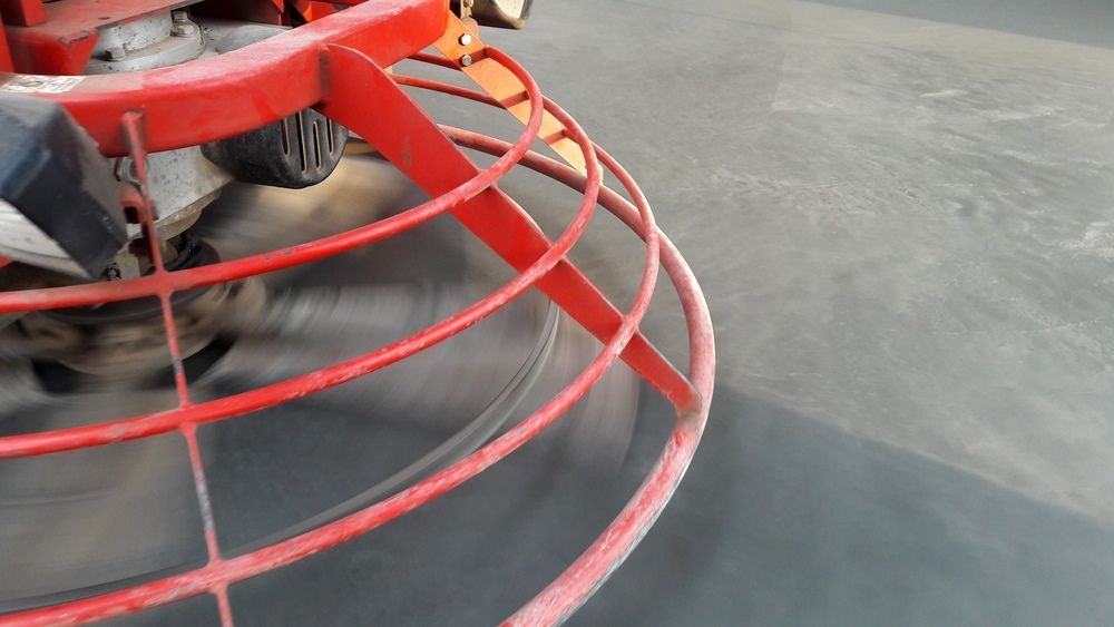 A Red Machine Is Spinning On A Black Surface — Fantastic Frank's Concrete Resurfacing In Ballina, NSW