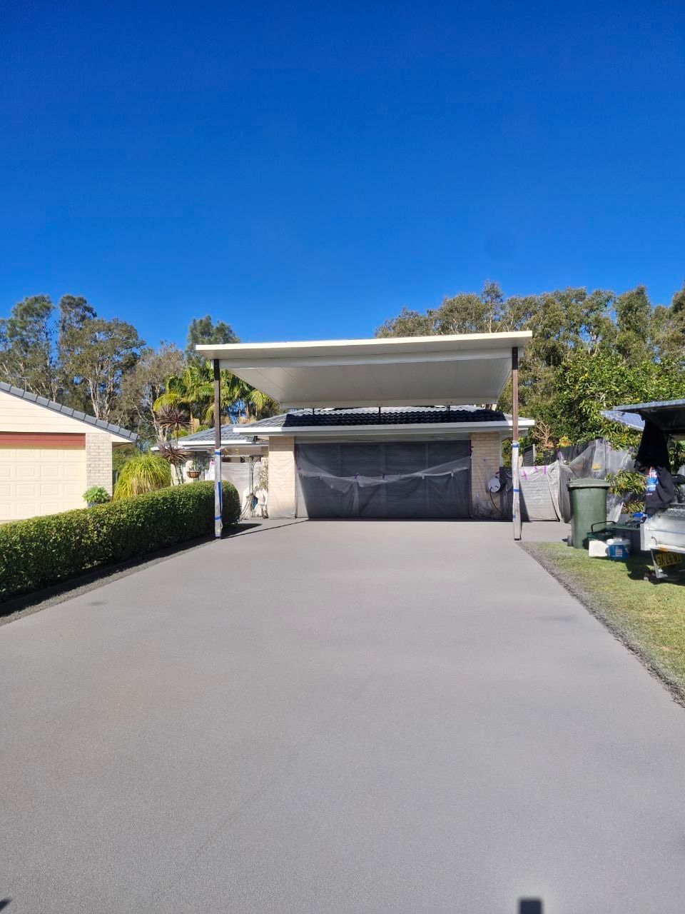 A driveway leading to a house with a boat parked in front of it — Fantastic Frank's Concrete Resurfacing In Byron Bay, NSW