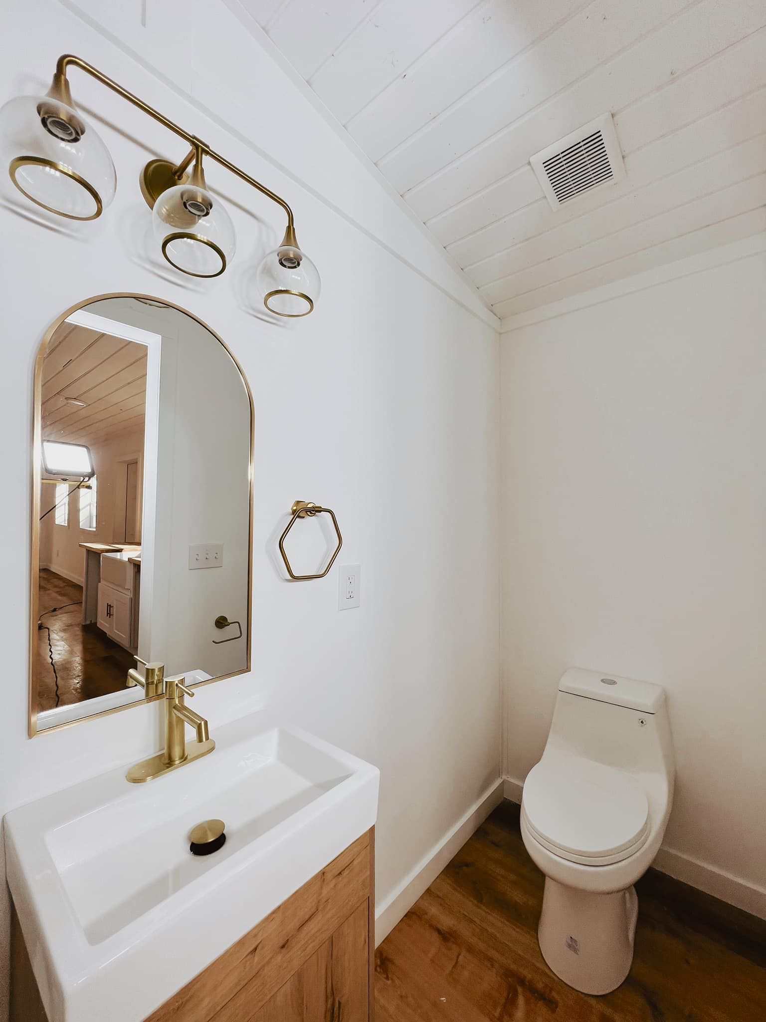 A bathroom with a sink , toilet and mirror.