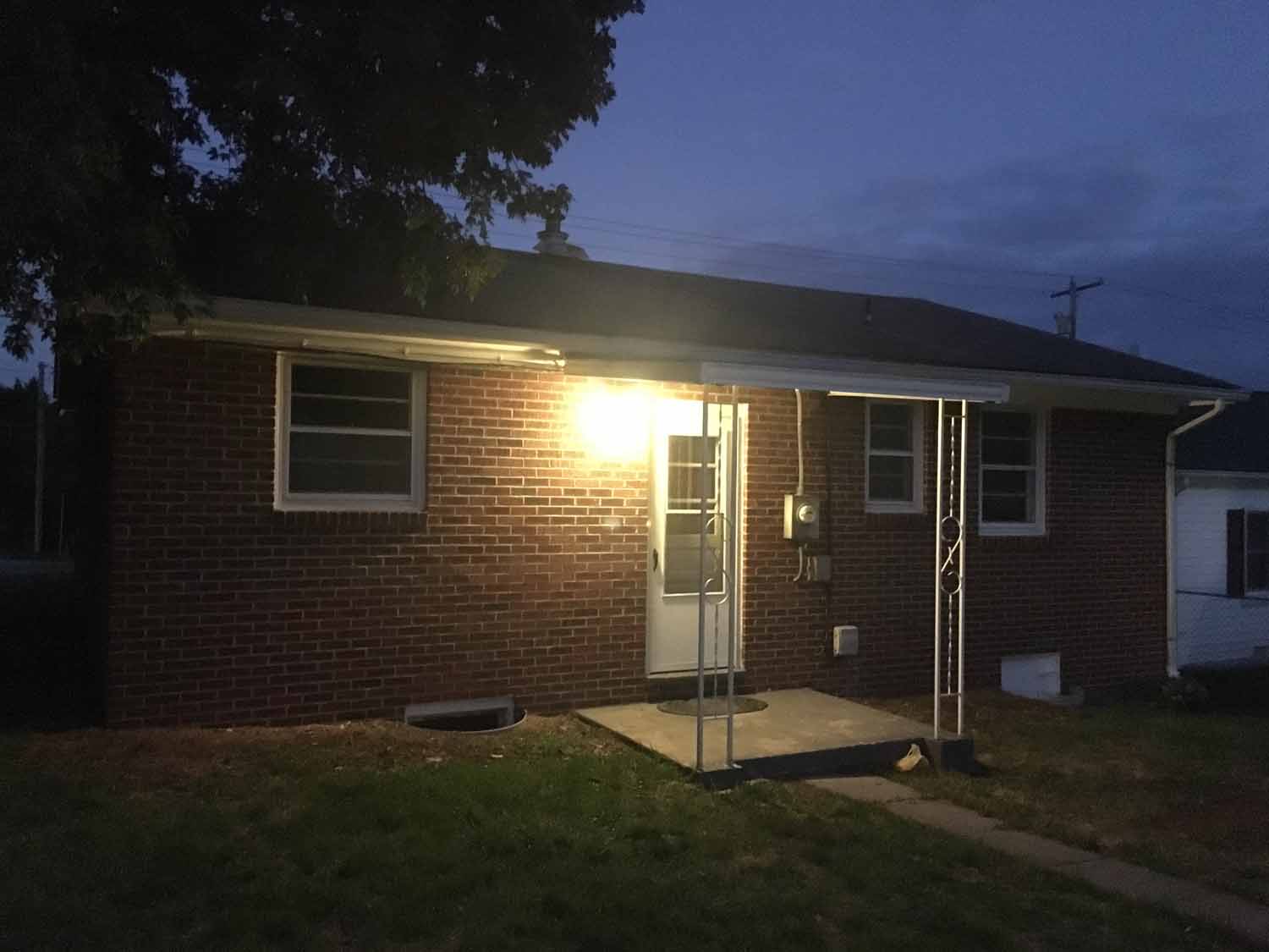 Front of a house with the porch light on