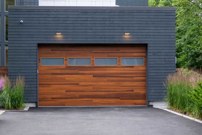 A wooden garage door is sitting in front of a house.