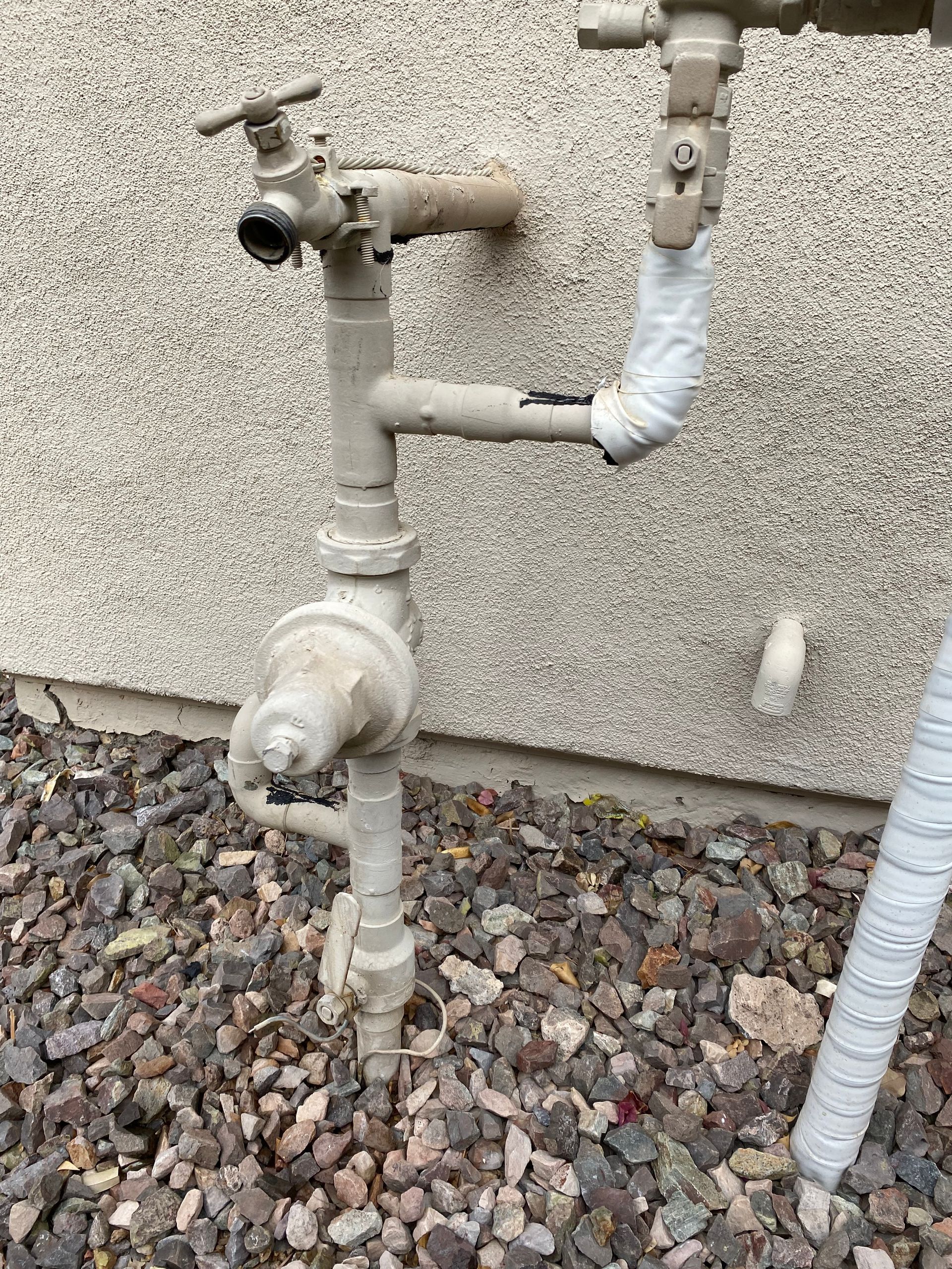 A close up of a water pipe on the side of a building.